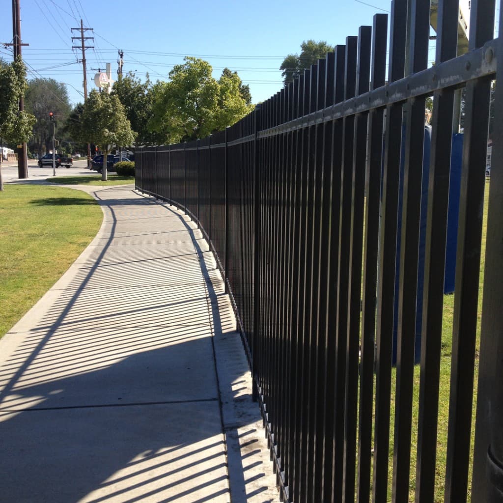 Ornamental steel fence along a city sidewalk