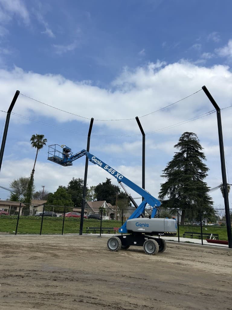 Tall netting poles being installed at a ball field
